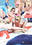 She swims in the sea topless before going back to the beach to sunbathe with her supple breasts on display 4