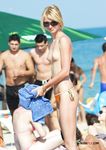 She swims in the sea topless before going back to the beach to sunbathe with her supple breasts on display 4
