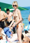 She swims in the sea topless before going back to the beach to sunbathe with her supple breasts on display 4