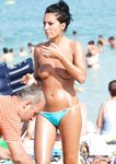 She swims in the sea topless before going back to the beach to sunbathe with her supple breasts on display 4