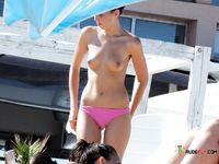 Topless u moře s kopci v dálce