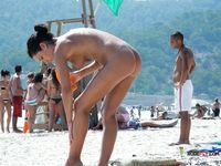 Dazzling blonde with a slim body and small tits walks around the beach topless 2