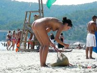 Dazzling blonde with a slim body and small tits walks around the beach topless 2