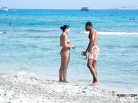 Dazzling blonde with a slim body and small tits walks around the beach topless 2