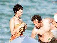 Holding a Wooden Board at a Topless Beach