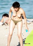 Holding a Wooden Board at a Topless Beach
