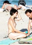 Holding a Wooden Board at a Topless Beach