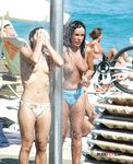 Oranžové spodní díly plavky při topless procházce mělkou vodou