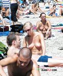 She takes photos with her camera with her perky tits out while another dashing brunette nearby also enjoys her day topless 4