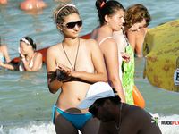 This nude beach girl enjoys tanning her fit, slim body with a pair of supple, rounds breasts on display 3