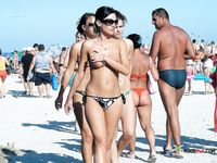 A Colorful Umbrella Frames Her Topless Beach Walk