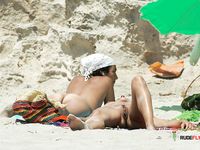 Voluptuous naturist couple enjoys their time at the beach as they go for a swim and cuddle on the towels 2