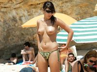 Corre y chapotea topless en las aguas poco profundas de la playa