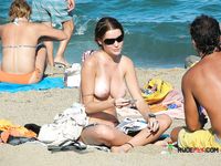 She enjoys tanning her massive, natural breasts topless after having left the water 4