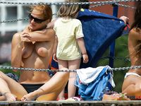 Brunette moms are naked together in nudist camp as they are getting tanned while displaying their small tits and trimmed pussies, not knowing they are watched by voyeur 2