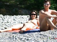 Brunette moms are naked together in nudist camp as they are getting tanned while displaying their small tits and trimmed pussies, not knowing they are watched by voyeur 2
