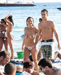 Relax topless en playa de arena con el océano al fondo