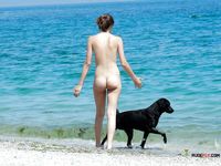 Brunette MILF with big tits is sitting on the beach joined by her husband as she spreads her legs wide to reveal her shaved pussy 2