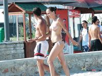 Busy Beach Path for a Confident Topless Walk Among Sunbathers