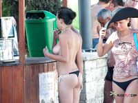 Busy Beach Path for a Confident Topless Walk Among Sunbathers