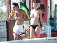 Busy Beach Path for a Confident Topless Walk Among Sunbathers