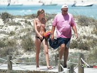 Nude Figure Walks the Shore as Ocean Waves Break Nearby