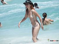 Cute brunette nudist with sunglasses enjoys her time on the beach 2