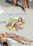 Tanned nudist hottie relaxes in the sun and enjoys a hot summer day at the beach