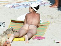 Tanned nudist hottie relaxes in the sun and enjoys a hot summer day at the beach