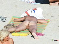 Tanned nudist hottie relaxes in the sun and enjoys a hot summer day at the beach