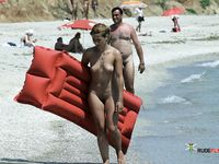 She sits in the sand topless, with her magnificent breasts showing freely 3