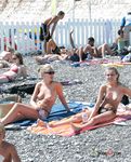 She sits in the sand sunbathing her magnificent, natural breasts and her smooth snatch