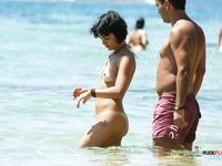 Gemeinsam durch flaches Wasser am Oben-ohne-Strand