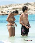 Druk zonnig strand: topless wandelaars op het zand