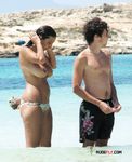 Druk zonnig strand: topless wandelaars op het zand