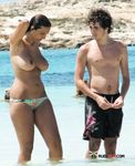 Druk zonnig strand: topless wandelaars op het zand