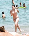 She Fixes Her Black Bikini on a Sunny Umbrella Beach