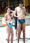 She sits in the sand topless and applies sunscreen on her slim body and large, natural breasts 4