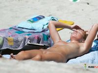 A sensual couple enjoys their day at the beach among a nudist colony while the sun heats their attractive, naked young bodies 2