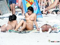 Voyeur catches a dashing nudist babe sunbathing naked on the beach 2