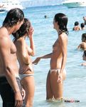 Slim and attractive ladies with bubbly asses and natural tits sit in the sand or walk around sunbathing