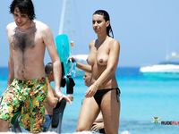 Playful brunette nudist sunbathes topless after having fun in the water 2