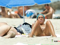 Busty nudist lady at a naked beach is just hanging around with her boobs out 2