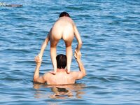 The natural beauty of a lady sunbathing topless on a quiet, sunny pier.