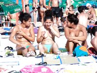 Přeplněná nudistická pláž z pohodlného místa v písku