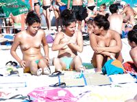 Přeplněná nudistická pláž z pohodlného místa v písku