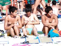 Přeplněná nudistická pláž z pohodlného místa v písku