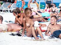 Přeplněná nudistická pláž z pohodlného místa v písku