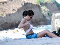 Capturing the graceful silhouette of a lady enjoying the ocean breeze in a topless fashion.