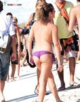 A lady enjoying the refreshing sea breeze in a natural, topless state.